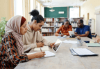 Three people talking in library