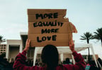 Person holding more equality sign