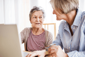 two senior citizens on a computer