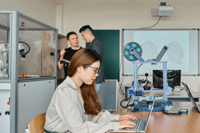 a person on their laptop in a school classroom
