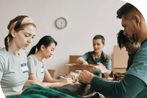 people preparing packages together at a table