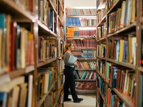 Person walking through bookshelves